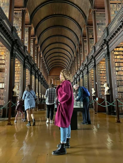 Étudiante dans une bibliothèque de Dublin pendant un programme scolaire en Irlande, entre expérience scolaire, étude et découverte culturelle.