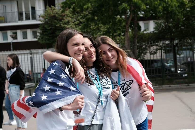 Studentesse abbracciate condividono un momento di amicizia durante il loro anno scolastico all’estero, tra scambio culturale, nuove relazioni e spirito internazionale.