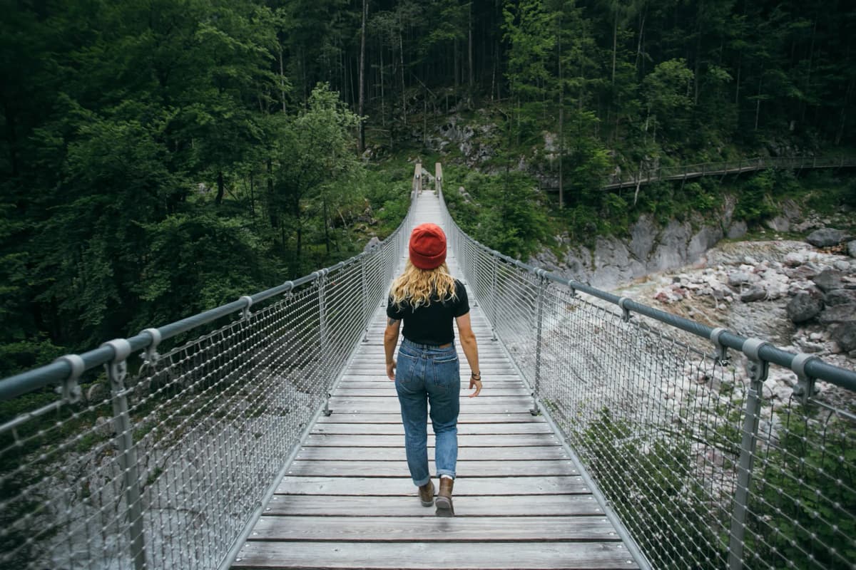 Étudiante marchant sur un pont en pleine nature, image de développement personnel lié au système scolaire canadien.