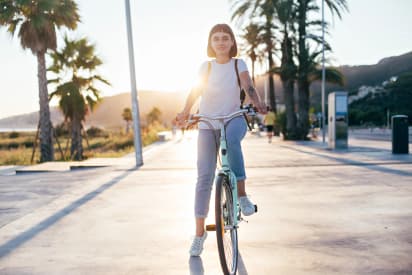 Cours de langue espagnole en Espagne en explorant la côte à vélo au coucher du soleil entre palmiers et mer