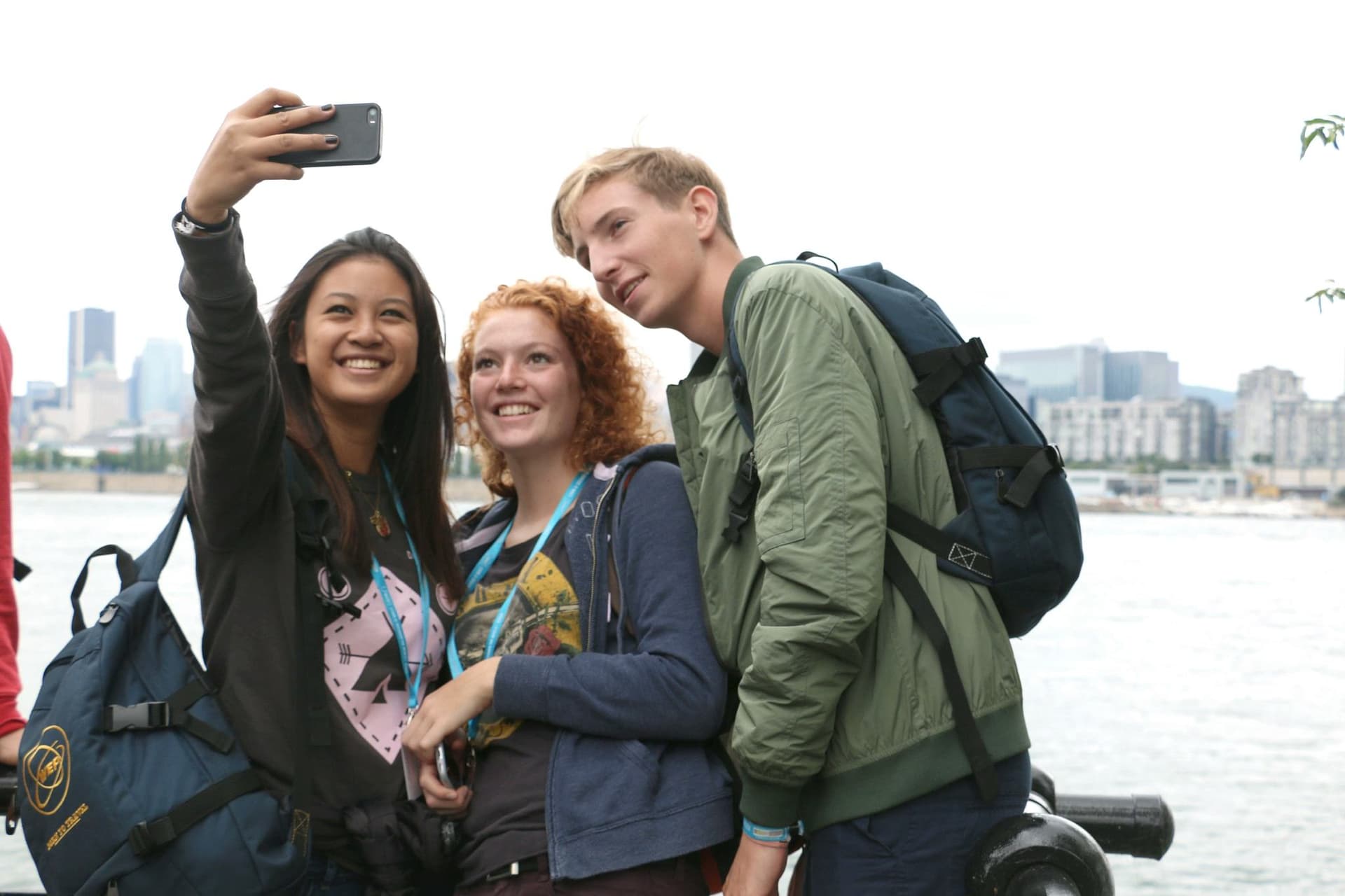 Étudiants prennent un selfie pendant un echange scolaire en Canada, au bord de l’eau avec vue sur la ville